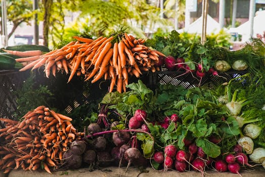 A vibrant display of fresh carrots, radishes, and greens at a local outdoor market.